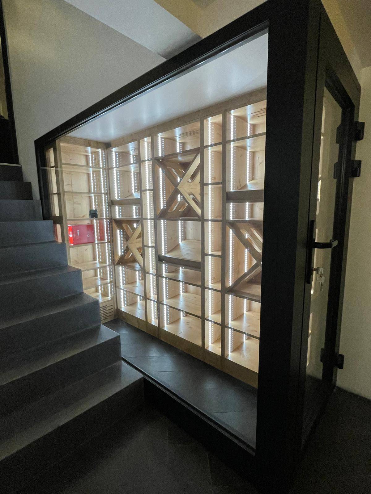 Création d'une cave à vin vitrée design dans une cage d'escalier dans une maison à Sainte-Adresse (76310)